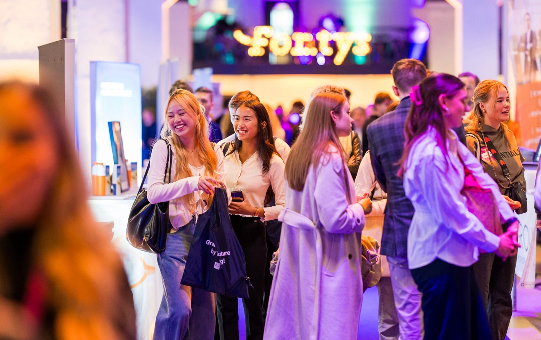 Sfeerfoto van het Fontys Career Event met glimlachende studenten