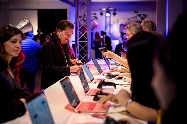 Registratiebalie met badges, keycords, bezoekers en hostessen