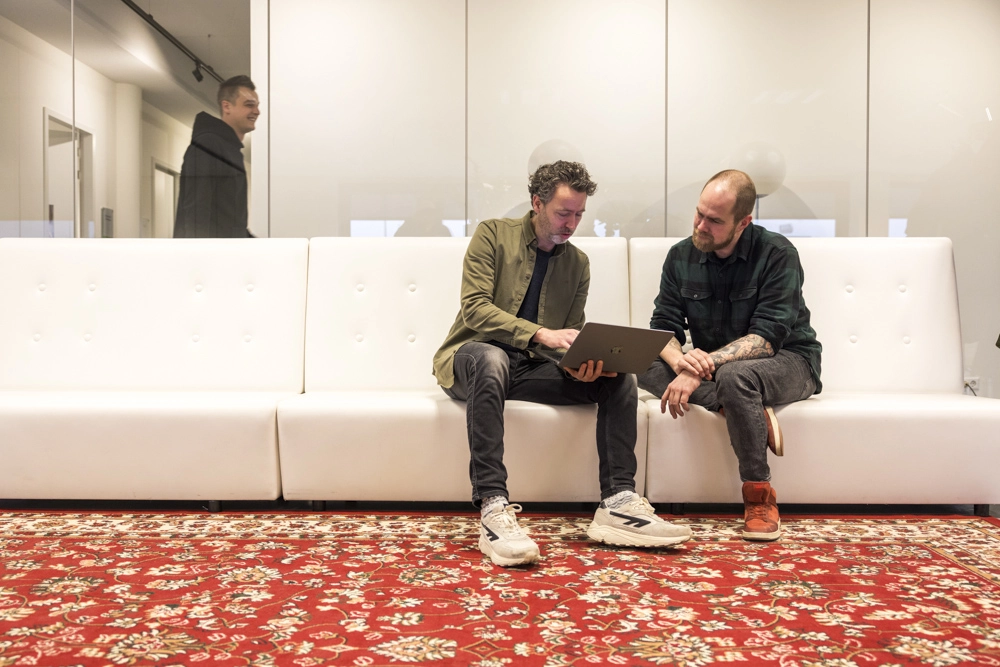 Een foto van JanJochem en Thijs die samen een project bespreken op de werkvloer.